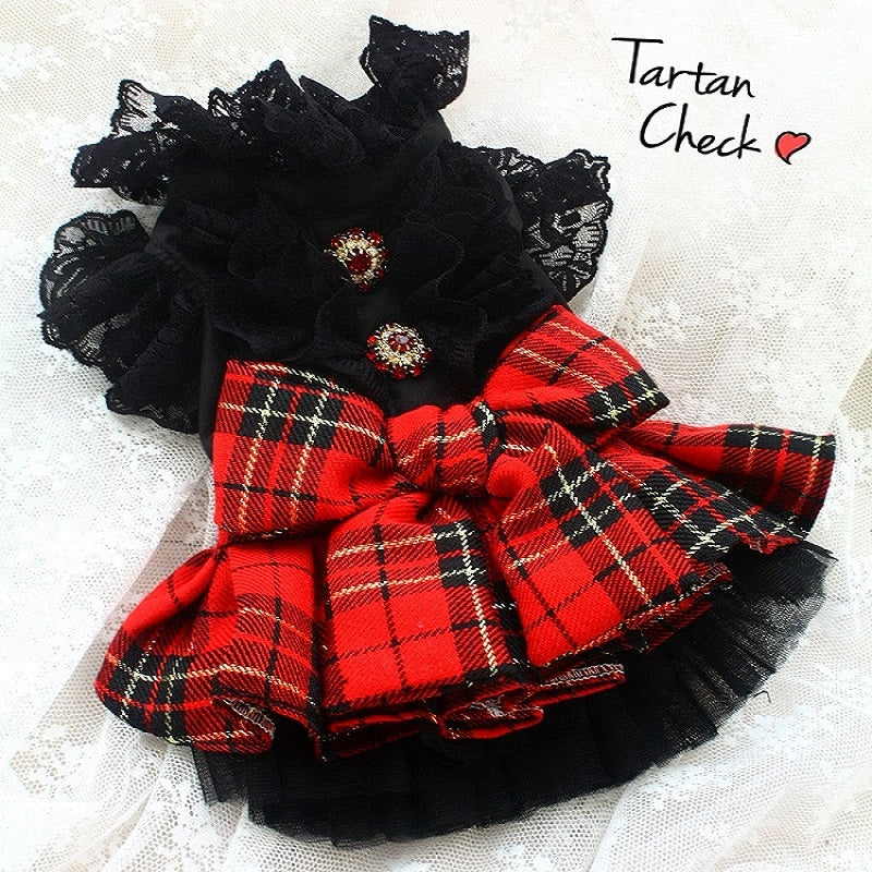 Red and black plaid pet dress with black ruffled collar on a white background