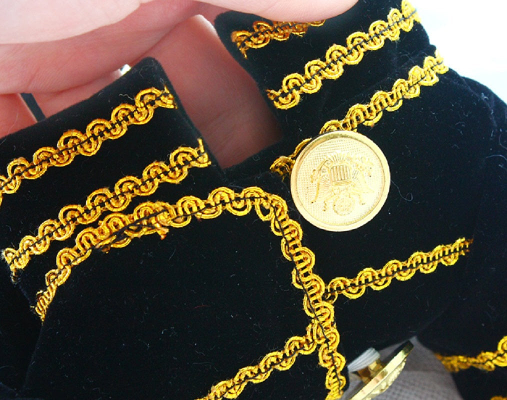 Gold coin with chain design on black velvet background