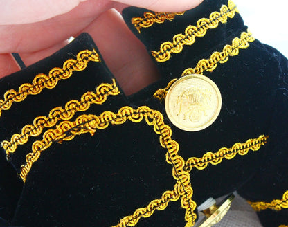 Gold coin with chain design on black velvet background