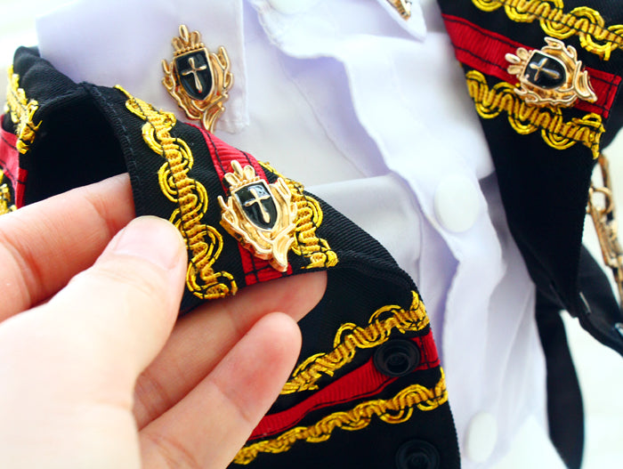 Close-up of a person holding a decorative ribbon with gold and black details.
