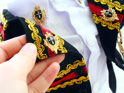 Close-up of a person holding a decorative ribbon with gold and black details.