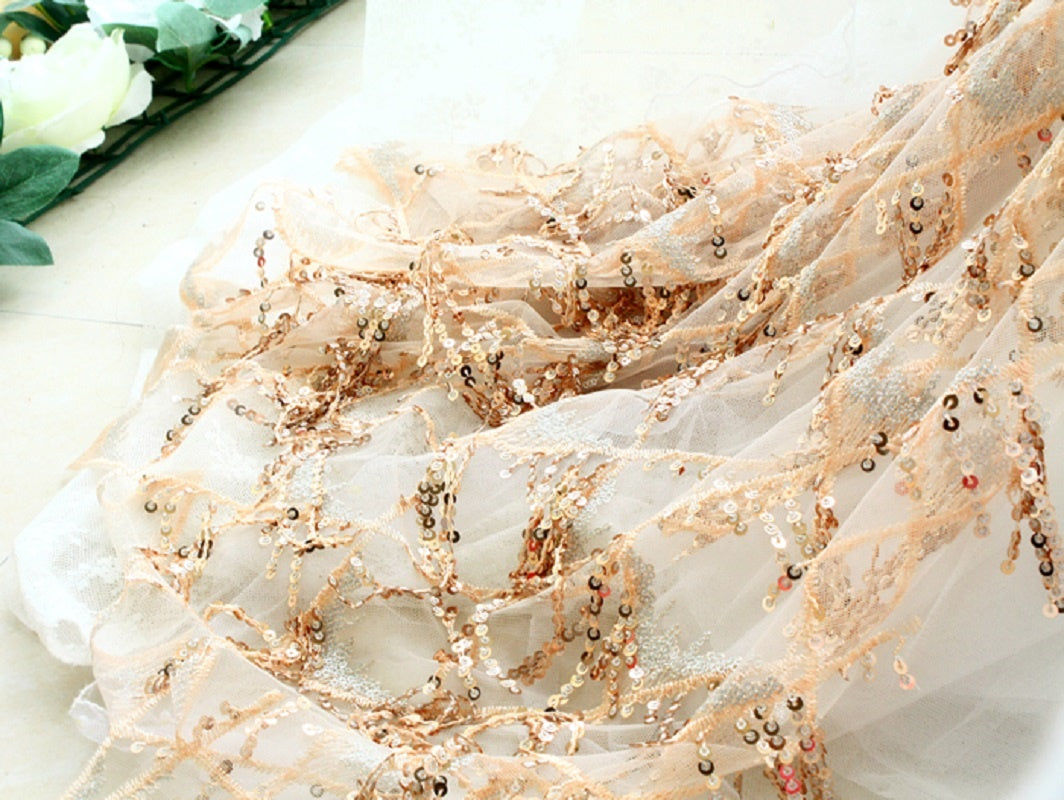 Close-up of a decorative fabric with gold embellishments on a white background