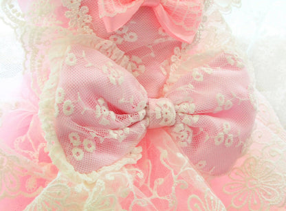 Pink and white lace bow with floral details on a soft pink background