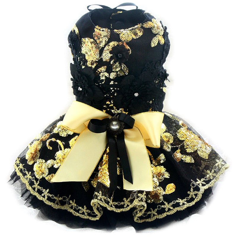 Black and gold decorative item with a bow on a white background