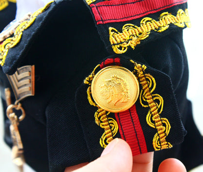 Close-up of a military uniform with a gold button and red and yellow details.