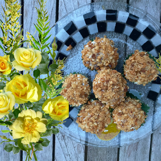 Baked balls on a glass plate with yellow flowers on a wooden surface