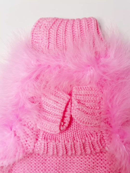 Pink knitted pet sweater with fluffy trim on a light background