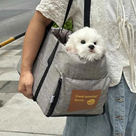 Small white dog in a gray pet carrier with 'Good morning! lovely...' text on a person's arm.