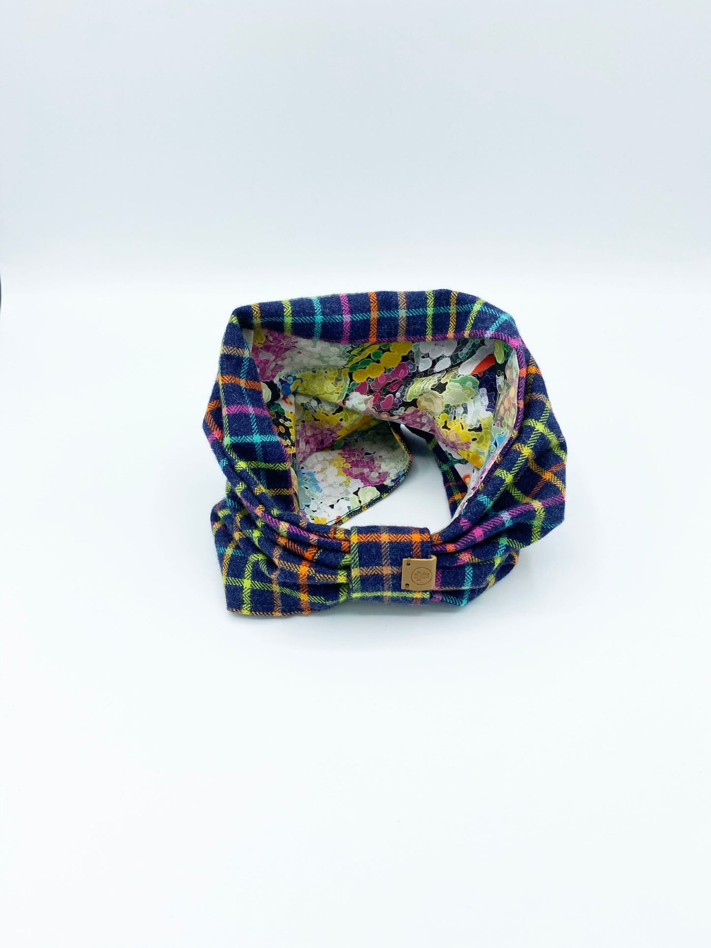 Multicolored plaid fabric with a floral pattern underneath on a white background
