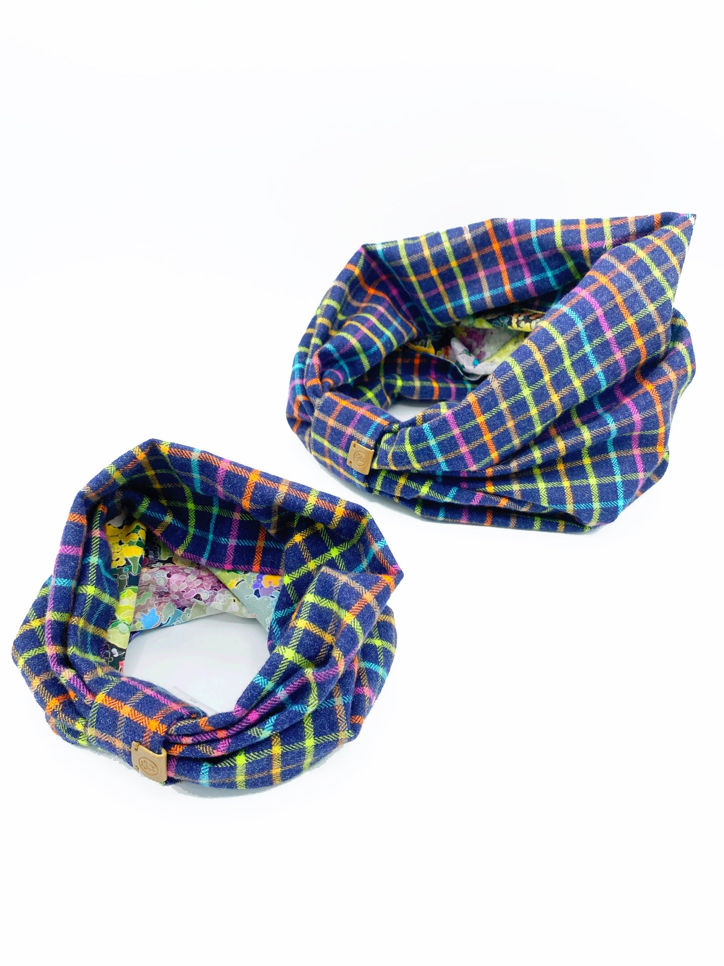 Two plaid neckwarmer scarves on a white background