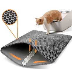 Gray cat litter mat with honeycomb pattern and a cat inspecting it, on a white background.