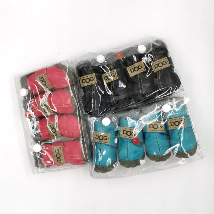 Packaged dog boots in pink, black, and blue on a white background