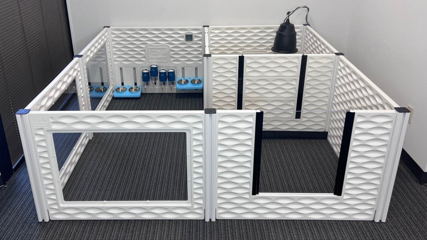 White pet playpen with transparent gate on a gray floor against a white wall.