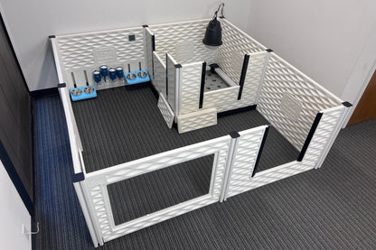 Pet playpen with multiple sections and accessories on a carpeted floor.