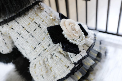 Black and white textured dress with a bow and flower detail on a blurred background