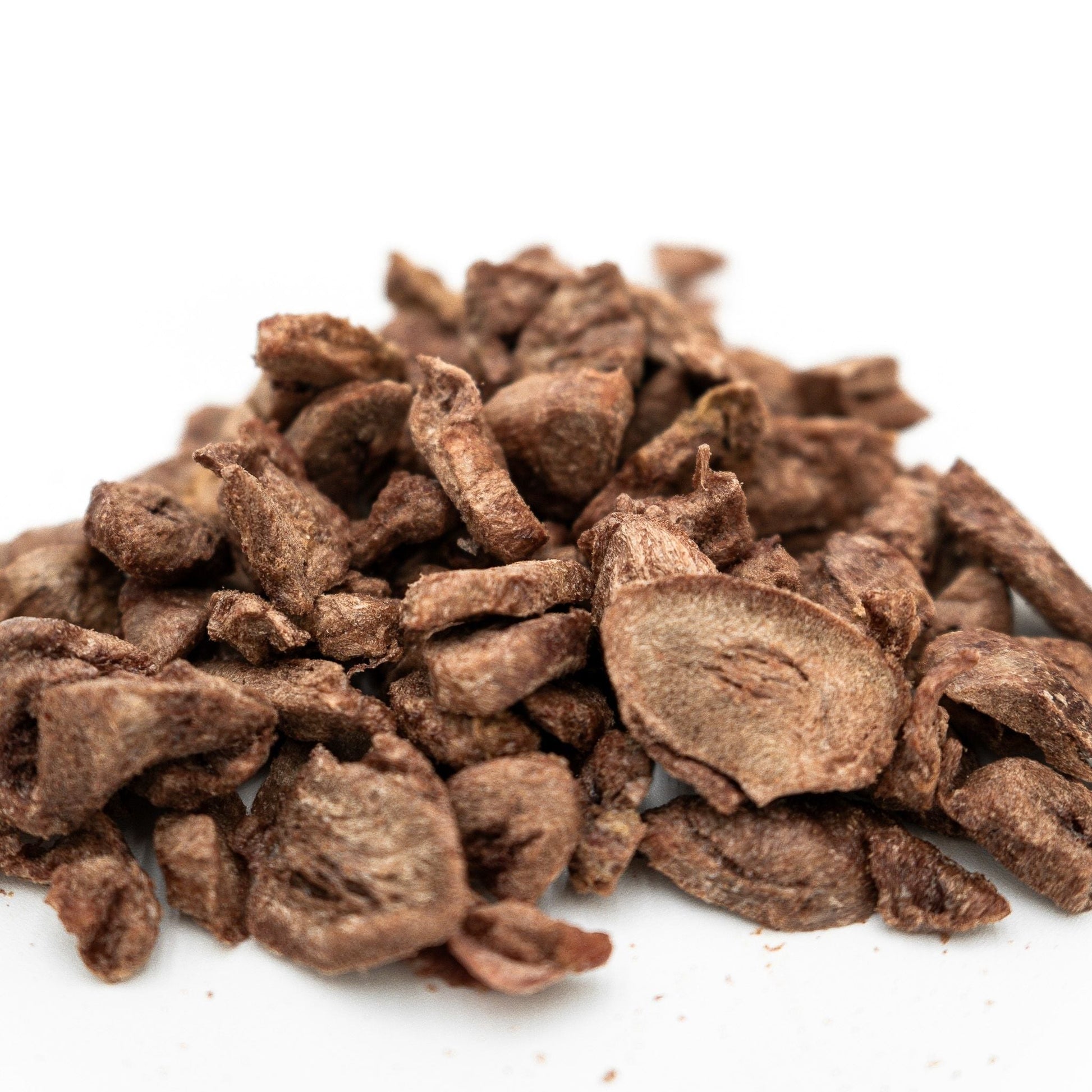 Heap of dried brown root vegetables on a white background