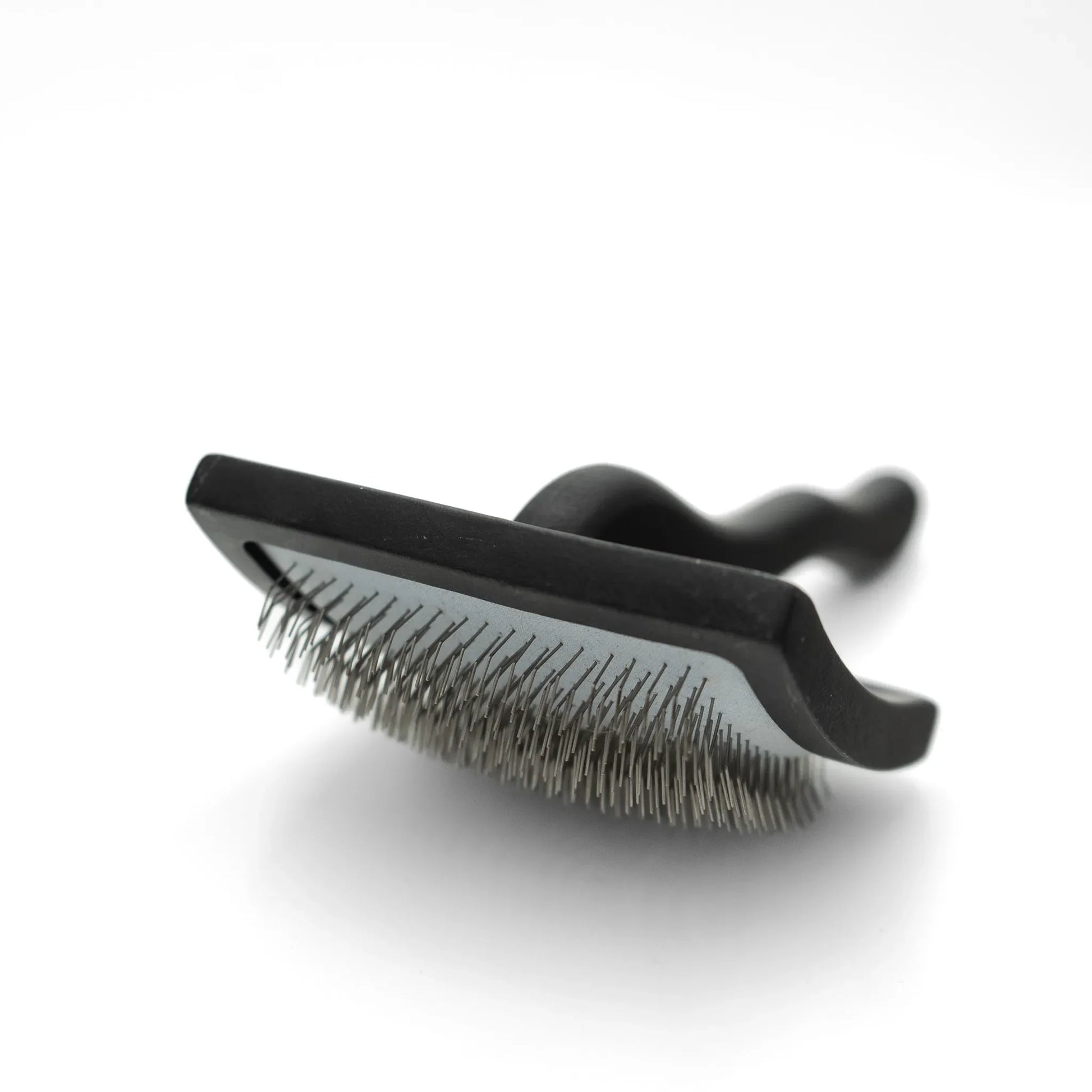 Black pet grooming brush on a white background