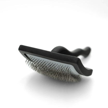 Black pet grooming brush on a white background