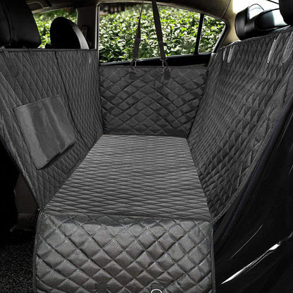 Car interior with quilted gray bench seat cover and a small blanket.