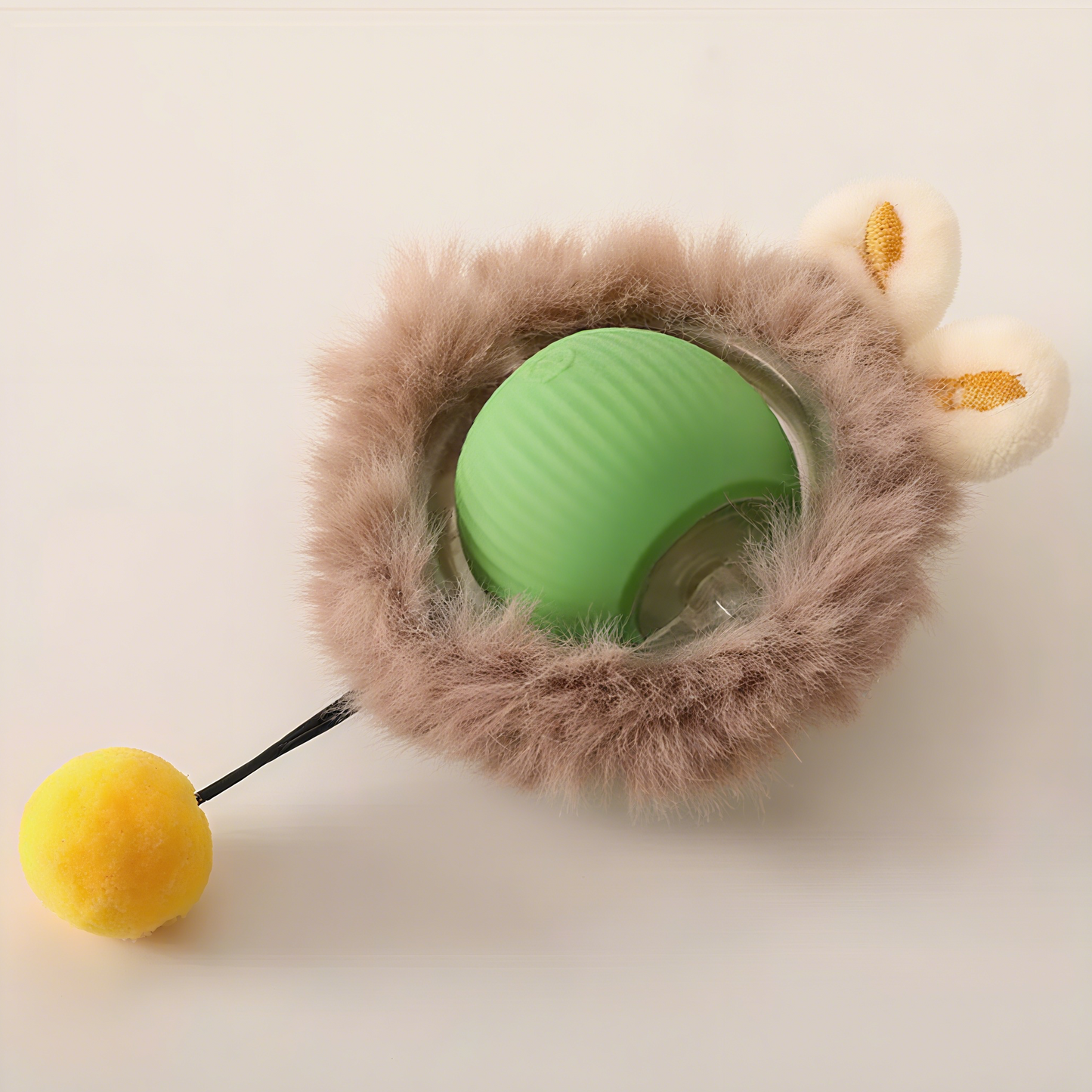 Green ball with a fluffy brown cover and yellow ball on a beige background