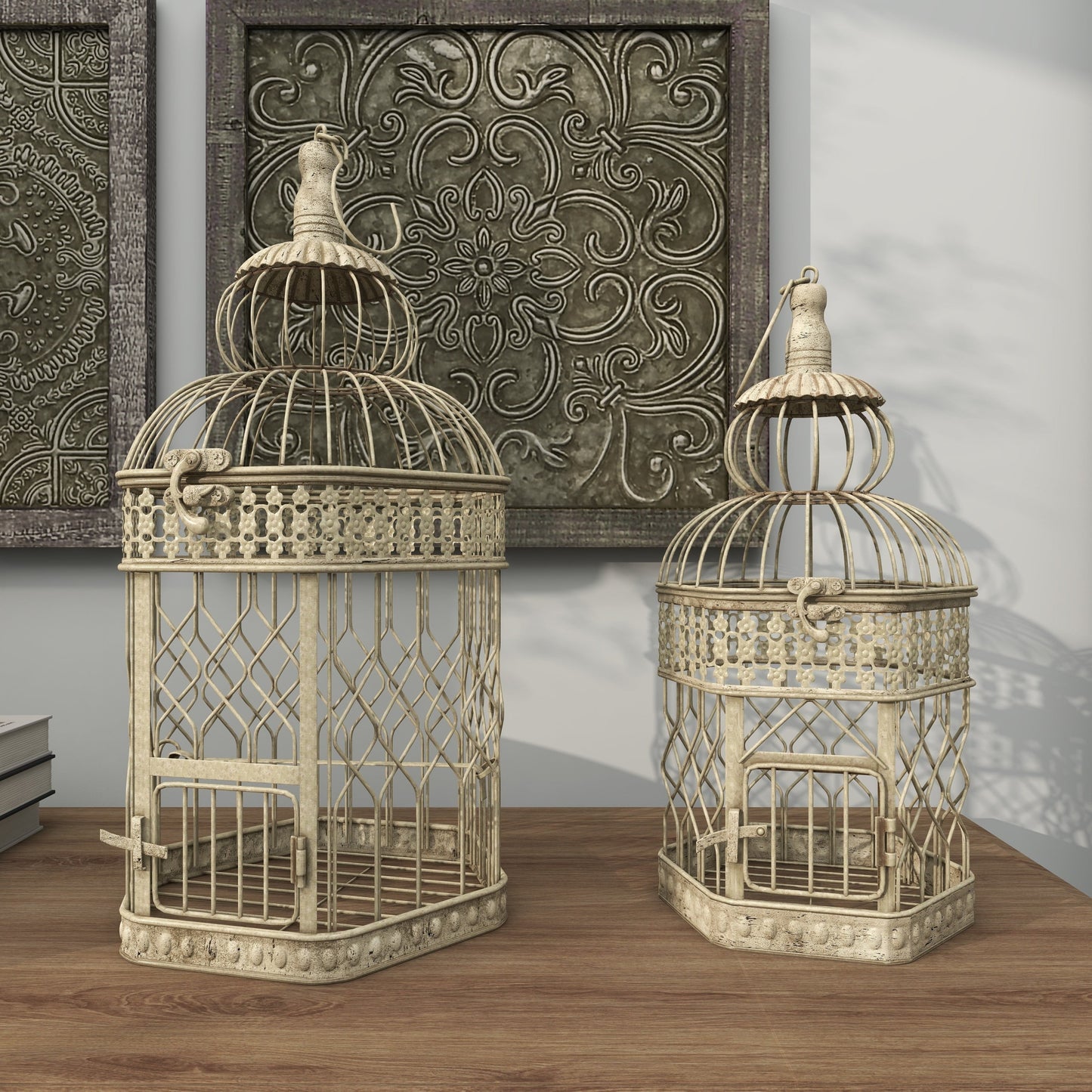 Two decorative birdcages on a wooden surface with ornate wall art in the background.