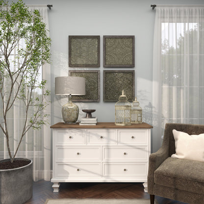 Living room with white dresser, lamp, and decor against a gray wall.