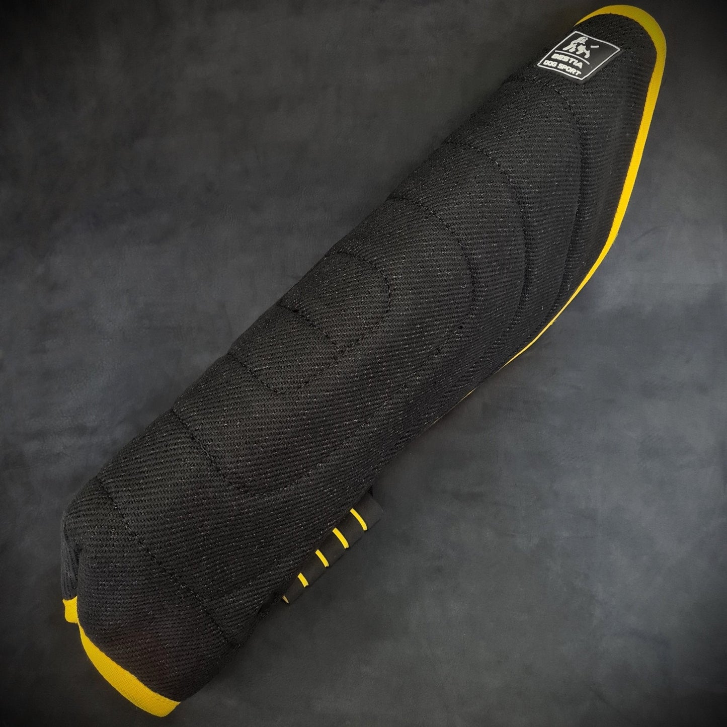 Black motorcycle seat cover with yellow accents on a dark background