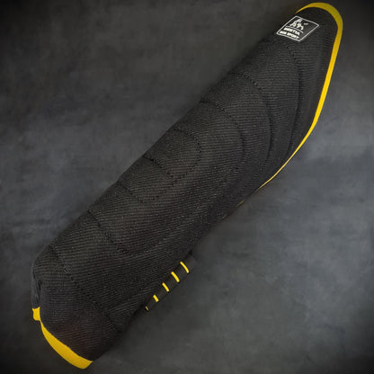 Black motorcycle seat cover with yellow accents on a dark background