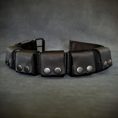 Black leather belt with silver studs on a gray background