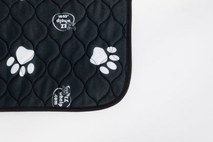 Black quilted pet mat with white paw prints on a white background