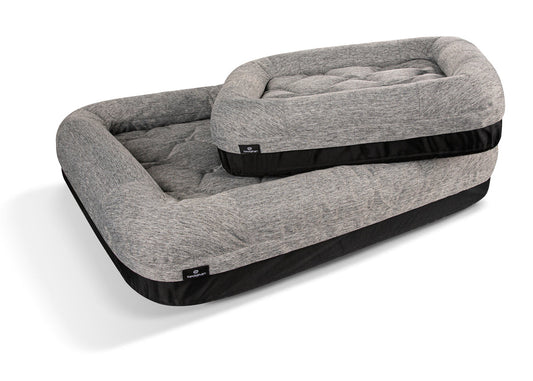 Gray pet bed with black trim on a white background