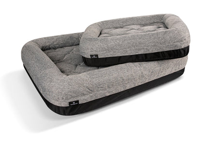 Gray pet bed with black trim on a white background