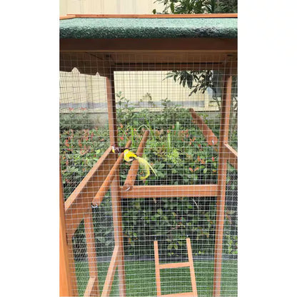 Birdcage with a green roof and wooden ladder against a blurred garden background