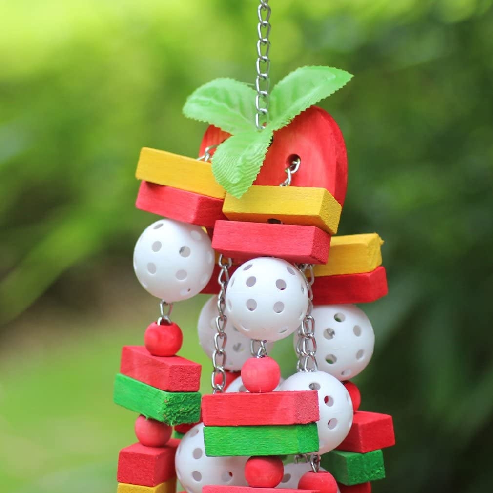Colorful bird toy with wooden blocks, beads, and a leaf against a green blurred background