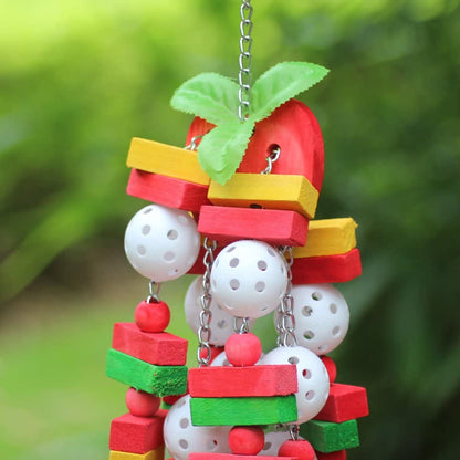 Colorful bird toy with wooden blocks, beads, and a leaf against a green blurred background