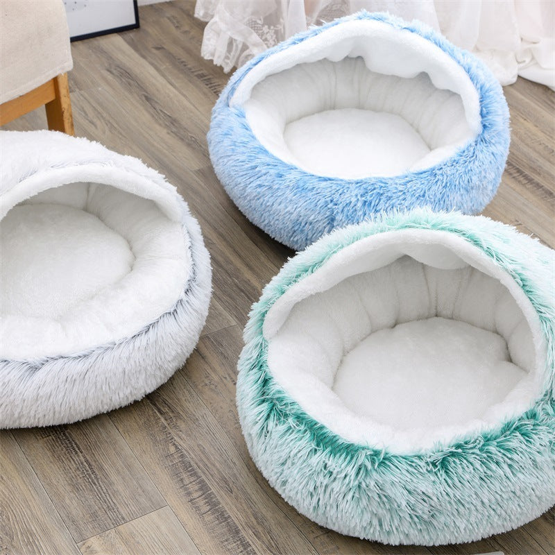 Three round, plush pet beds in blue, white, and green on a wooden floor.