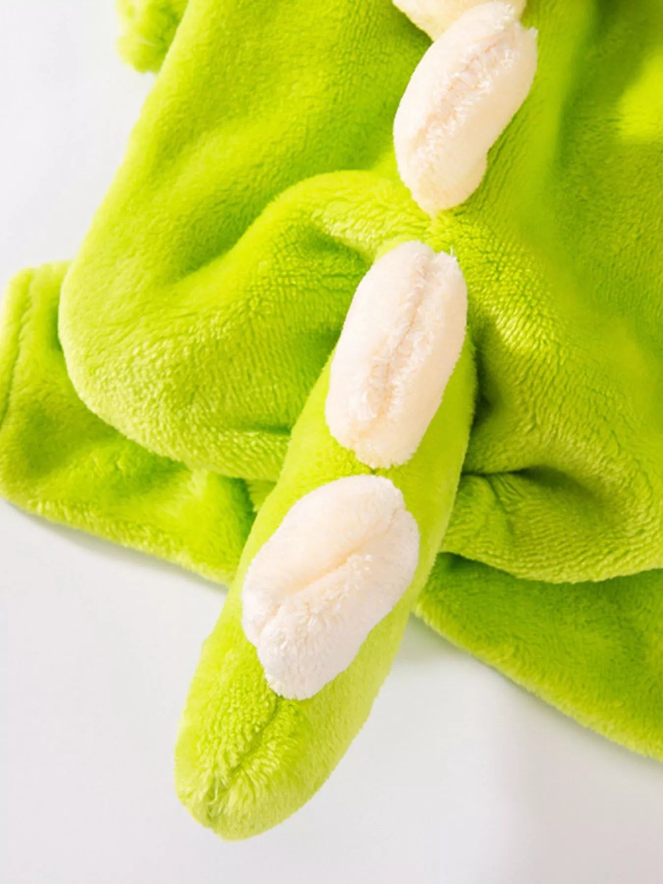 Green dinosaur costume with white spikes on a white background