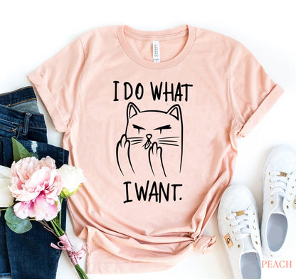 Pink t-shirt with a cat graphic and text, surrounded by jeans, sneakers, and flowers on a white background.