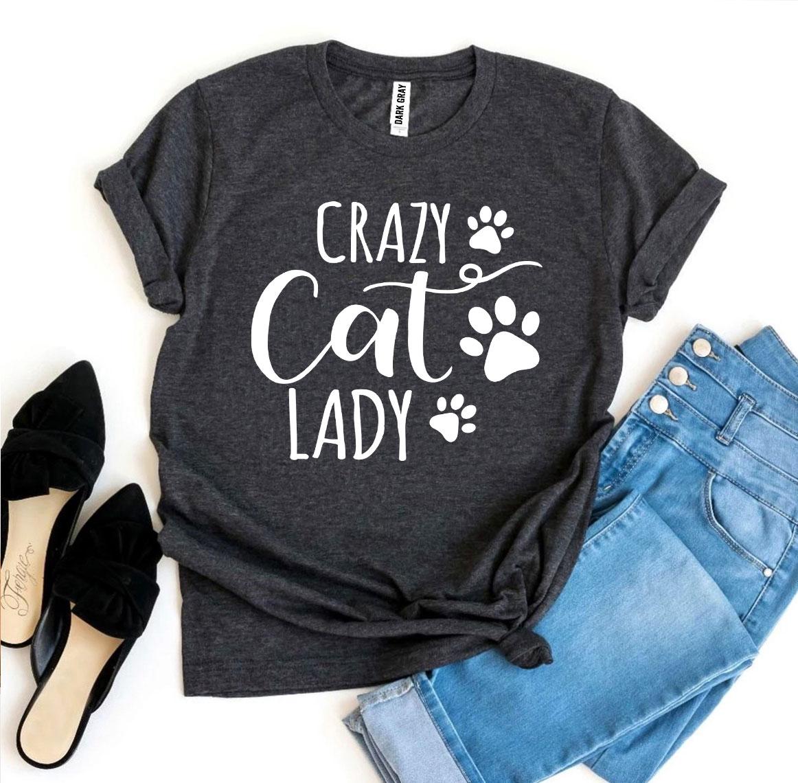 Dark gray t-shirt with 'Crazy Cat Lady' text and paw prints, paired with jeans and shoes on a white background.