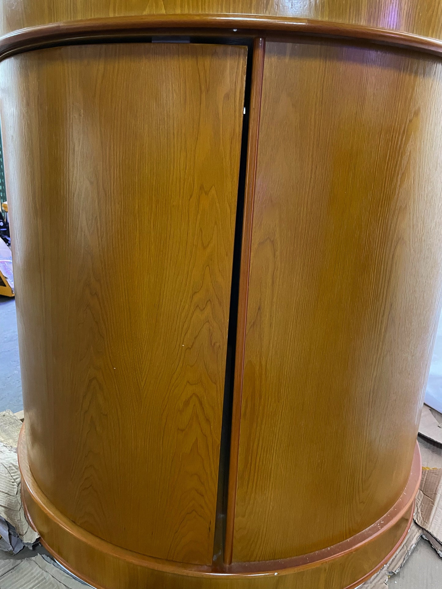 Wooden cylindrical object with a central seam on a plain background