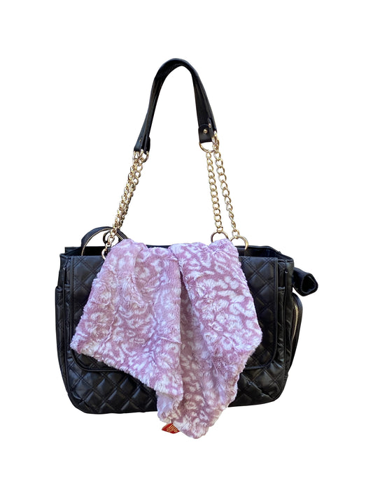 Black handbag with a gold chain strap and a purple scarf draped over it on a white background