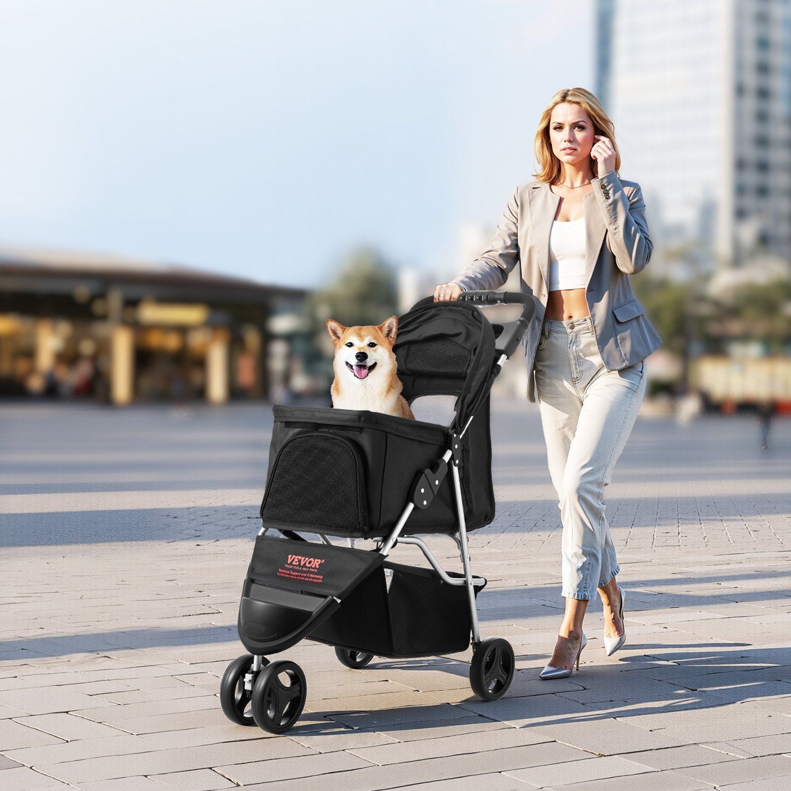Woman walking a dog in a stroller on a city street.
