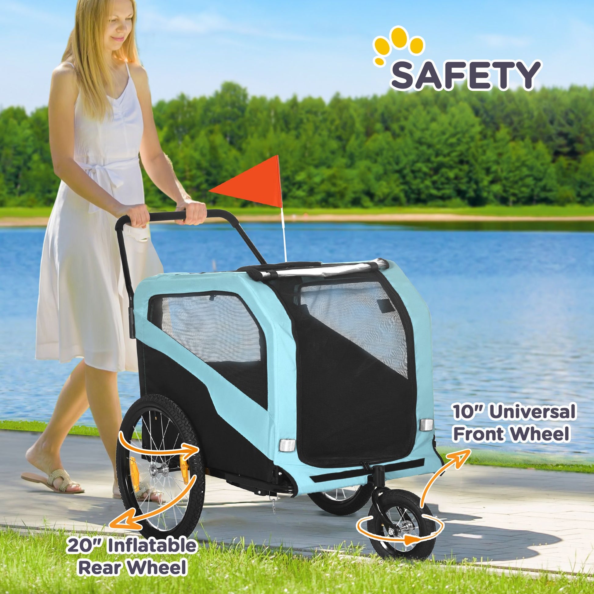 Woman pushing a light blue pet bike trailer with safety features highlighted, near a lake.