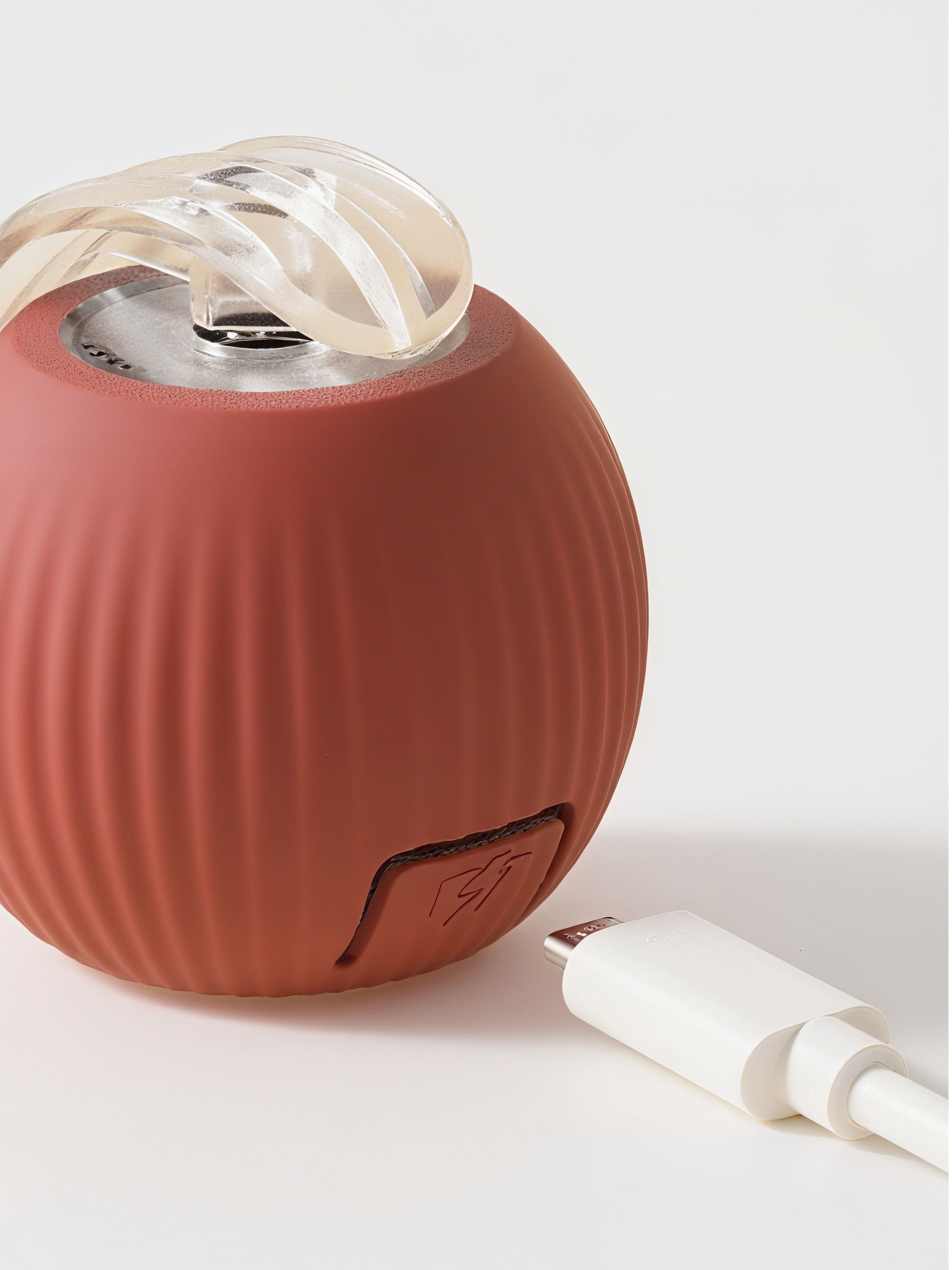 Red portable speaker with a white cable on a light gray background