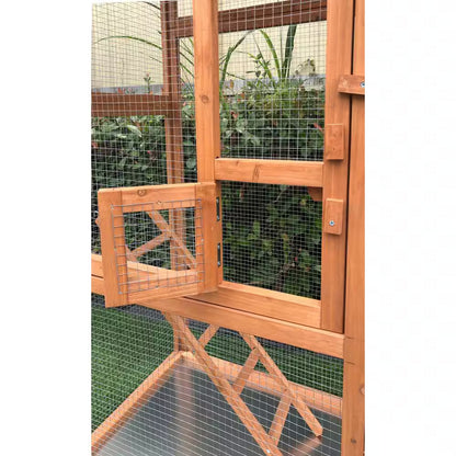 Wooden pet enclosure with mesh sides and a door, set against a green outdoor background.