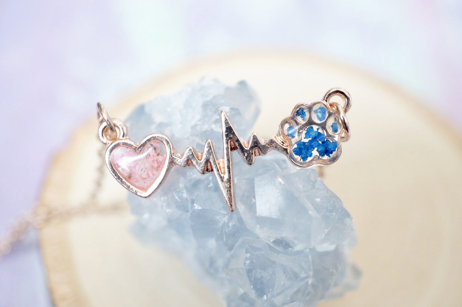 Jewelry set with heart, heartbeat symbol, and paw print on a crystal background