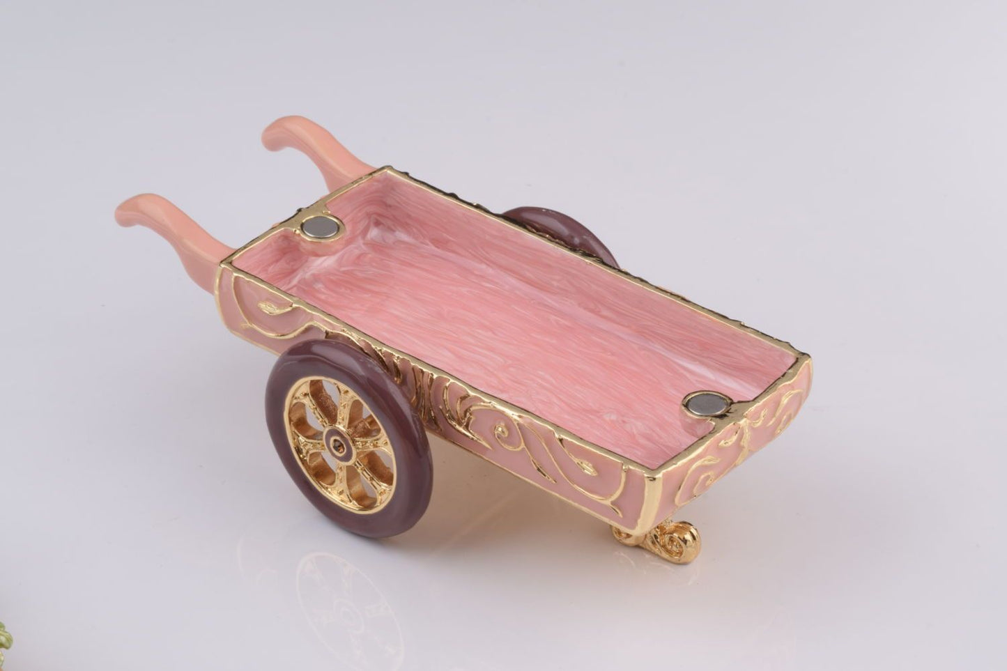 Decorative miniature cart with pink tray on a white background