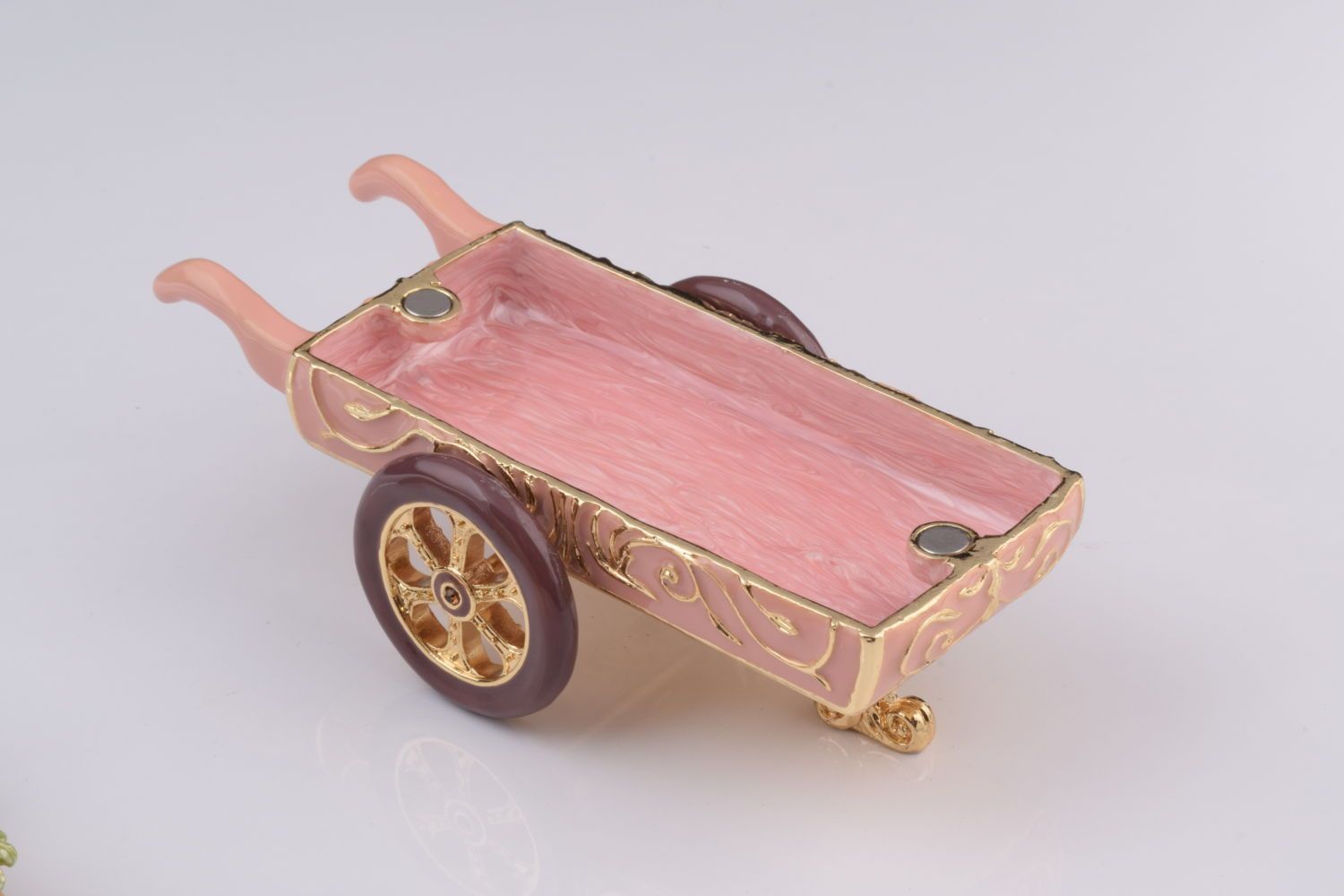 Decorative miniature cart with pink tray on a white background