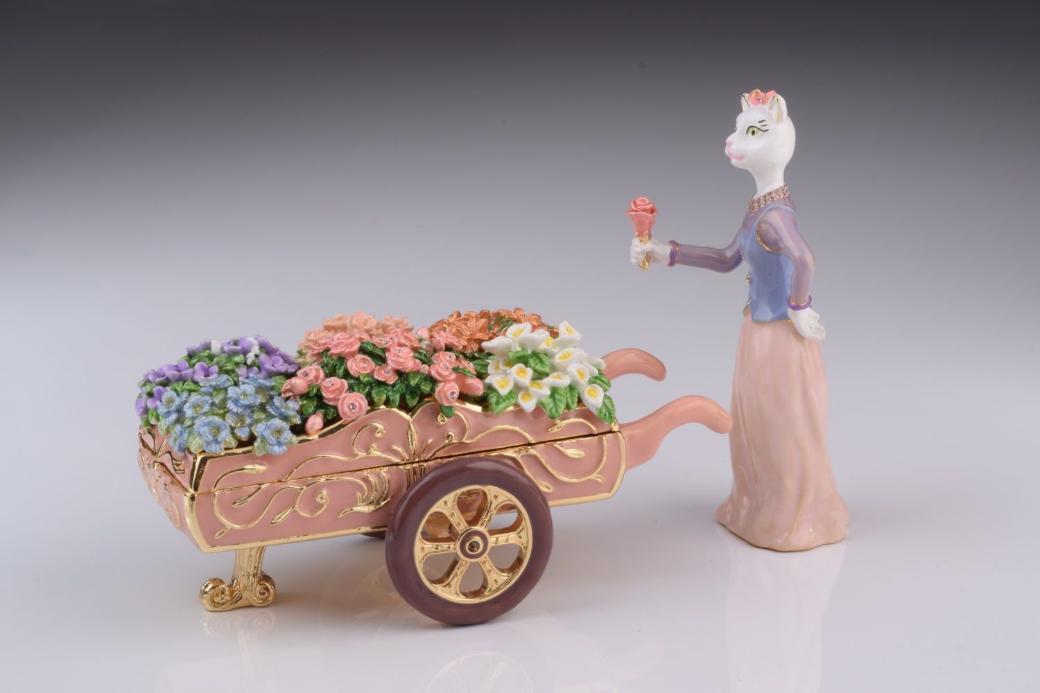 Porcelain figurine of a woman with a cart full of flowers on a gray background
