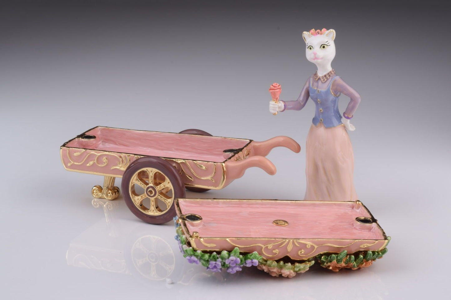 Decorative figurine of a woman with a cart on a gray background